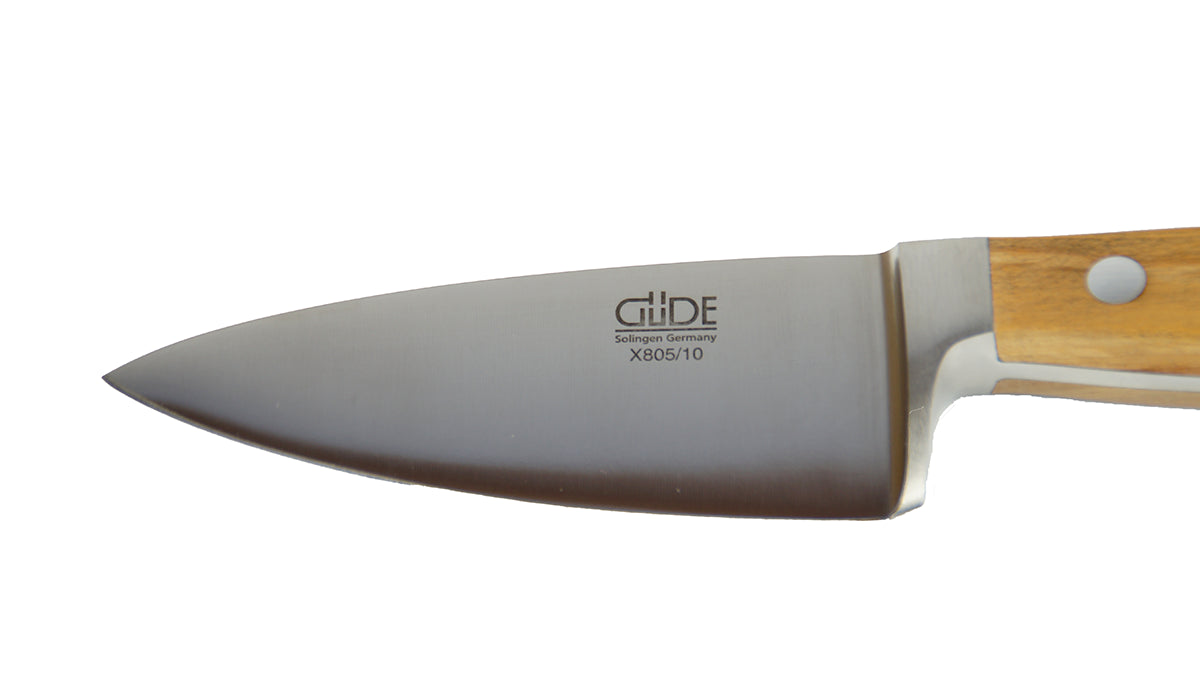 GÜDE Klinge des Hartkäsemesser Alpha Olive X805/10 mit 10 cm Klingenlänge und Olivenholz-Griff auf weißem Hintergrund