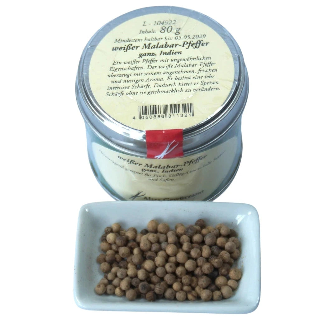 Altes Gewürzamt Weißer Malabar-Pfeffer Reifer indischer Sortenpfeffer, grüne Gewürzdose von oben und ein kleines Schälchen mit ganzen Pfefferkörnern auf hellem Hintergrund