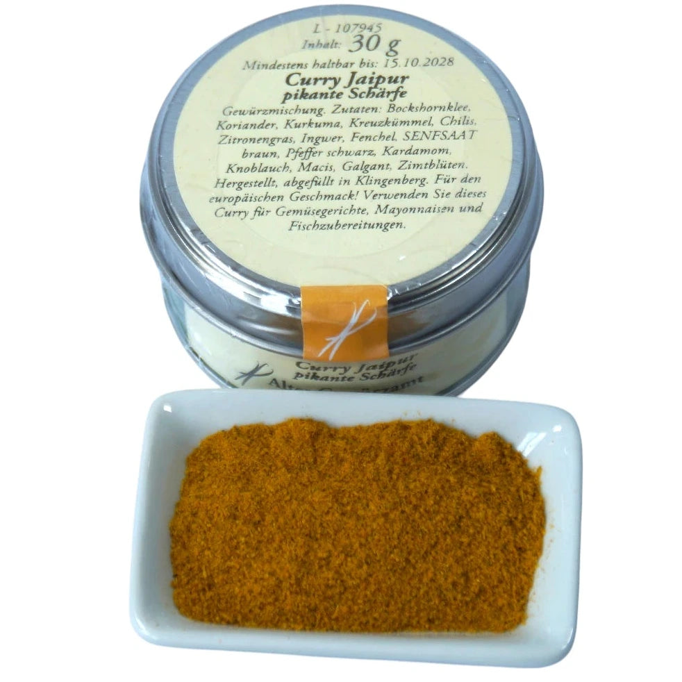 Altes Gewürzamt Curry Jaipur Pikant-frische Premium-Currymischung, grüne Gewürzdose mit Blick auf die Rückseite und ein kleines Schälchen mit Currypulver auf hellem Hintergrund