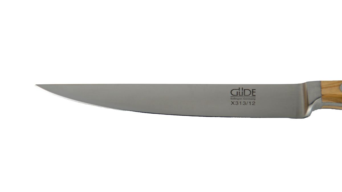 GÜDE Klinge des  Steakmesser glatte Schneide Alpha Olive X113/12 mit 12 Klingenlänge und Olivenholz-Griff auf weißem Hintergrund