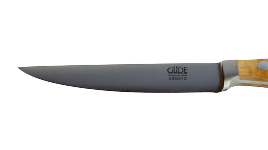 GÜDEKlinge des Porterhouse Steakmesser glatte Schneide Alpha Olive X180/12 mit 13 cm Klingenlänge und Olivenholz-Griff auf weißem Hintergrund