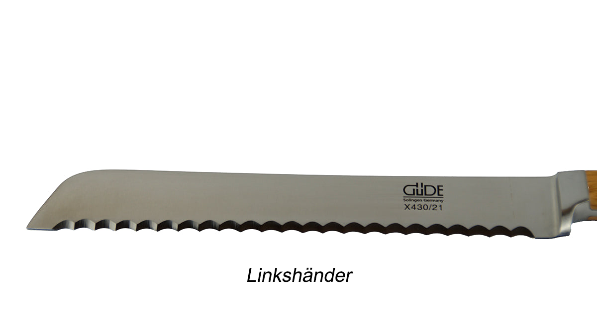 GÜDE klinge des Brotmesser X430/21L Alpha Olive mit 21 cm Klingenlänge und Olivenholz-Griff für Linkshänder auf weißem Hintergrund