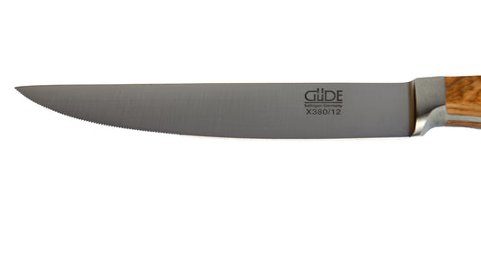 GÜDE Klinge des Porterhouse Steakmesser Alpha Olive X380/12 mit 12 cm Klingenlänge und Olivenholz-Griff auf weißem Hintergrund