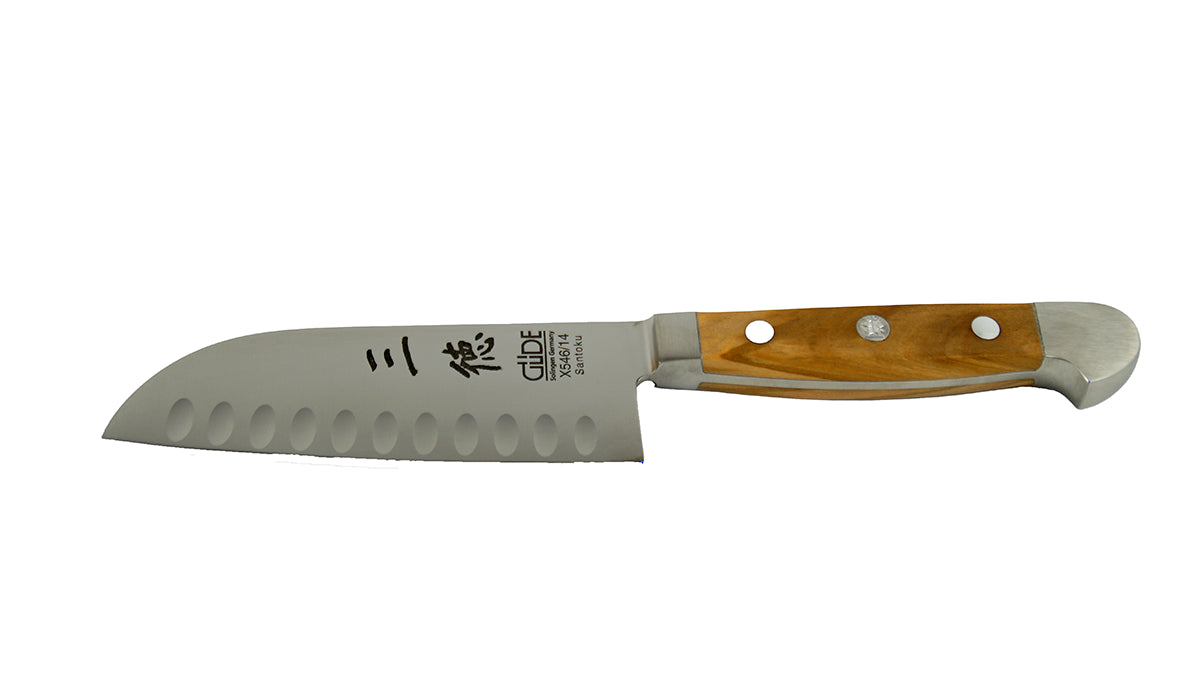 GÜDE Santoku Alpha Olive X546/14 – Japanisches Kochmesser mit Kullenschliff 14 cm Klingenlänge mit Olivenholz-Griff auf weißem Hintergrund